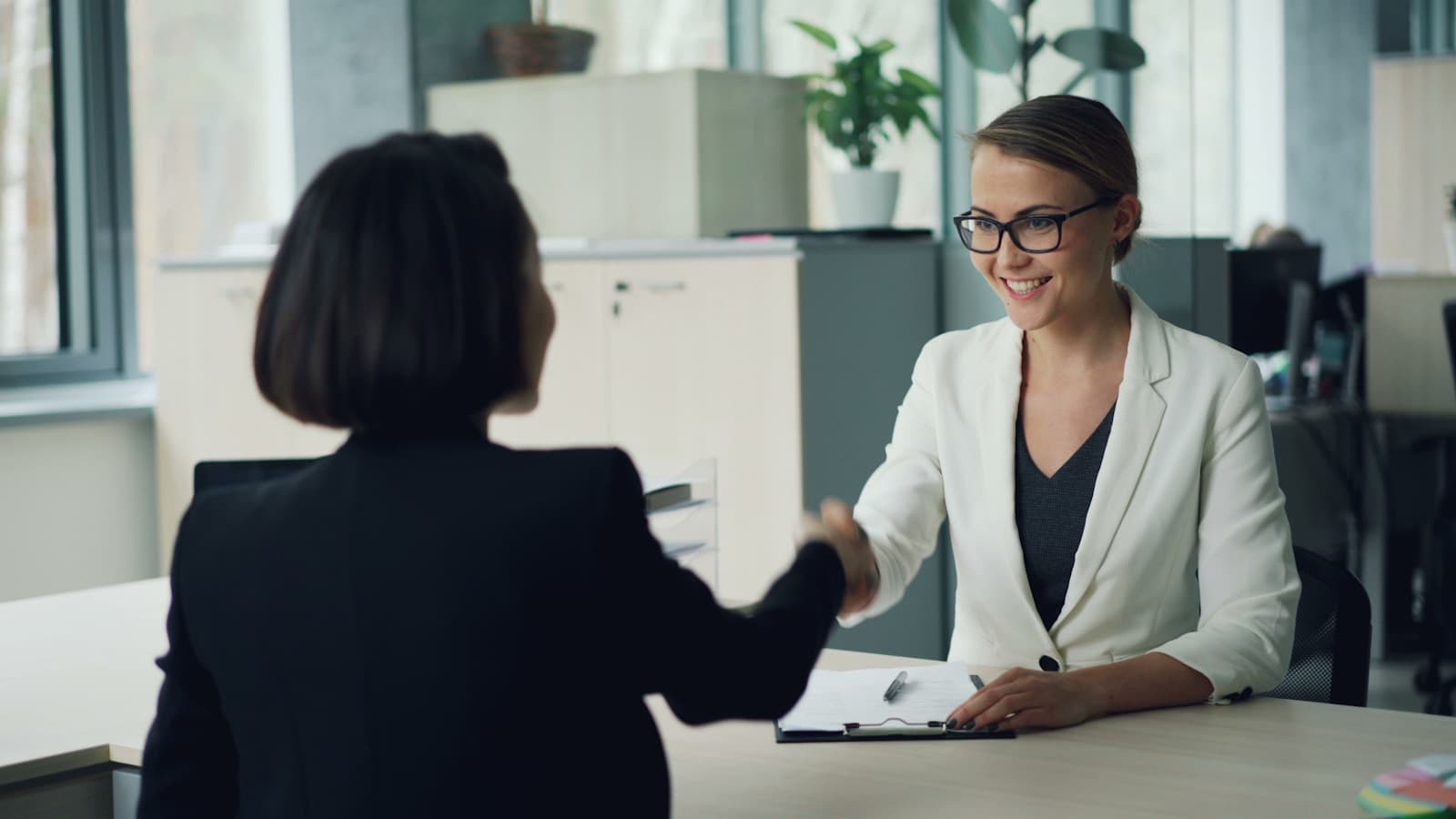 A recruiter shaking hands with a candidate after a successful placement